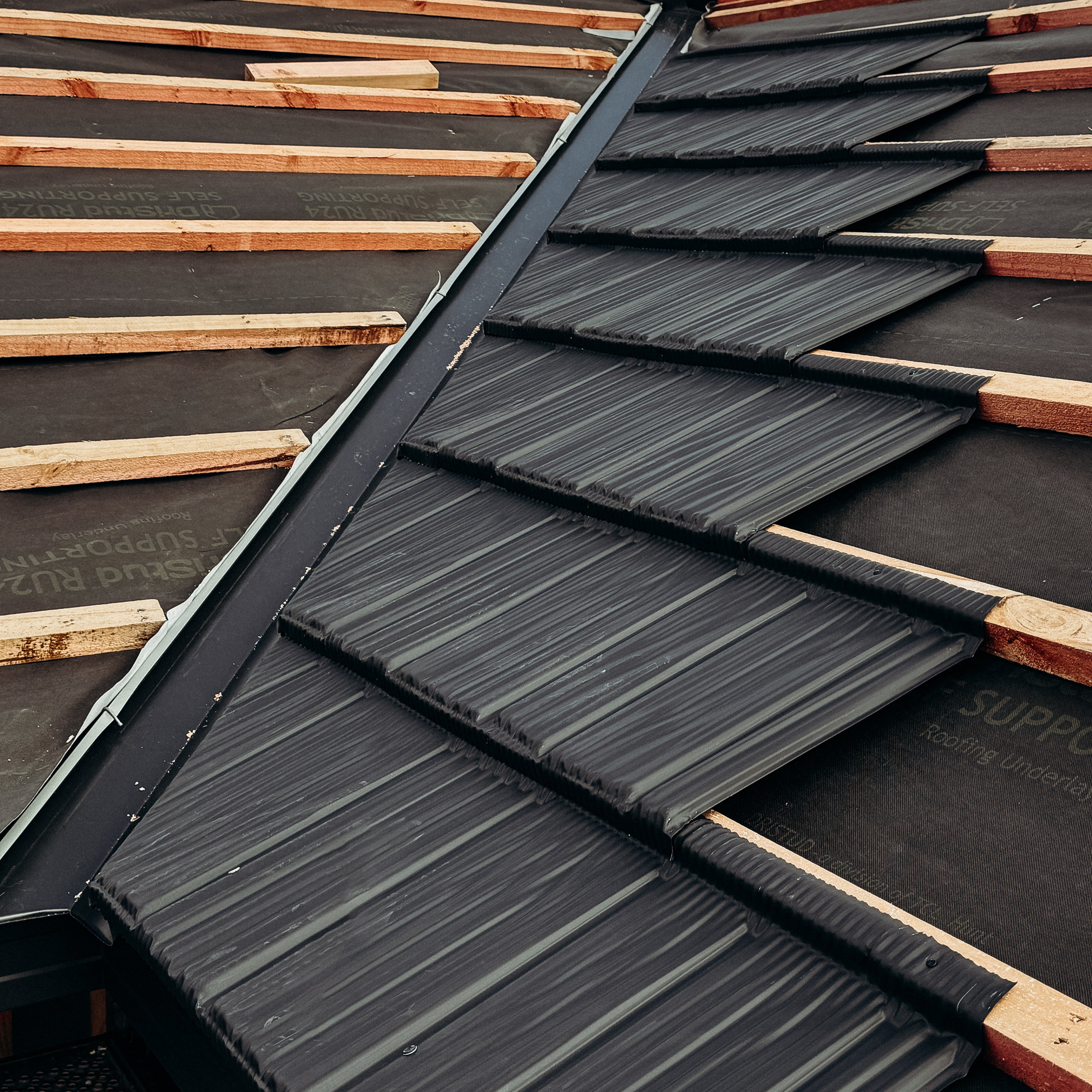 Gerard Roofing Tile installation in progress for a high-end Jennian Homes new build. Premium Windor Grey metal tiles being precisely laid for durability and weather resistance.