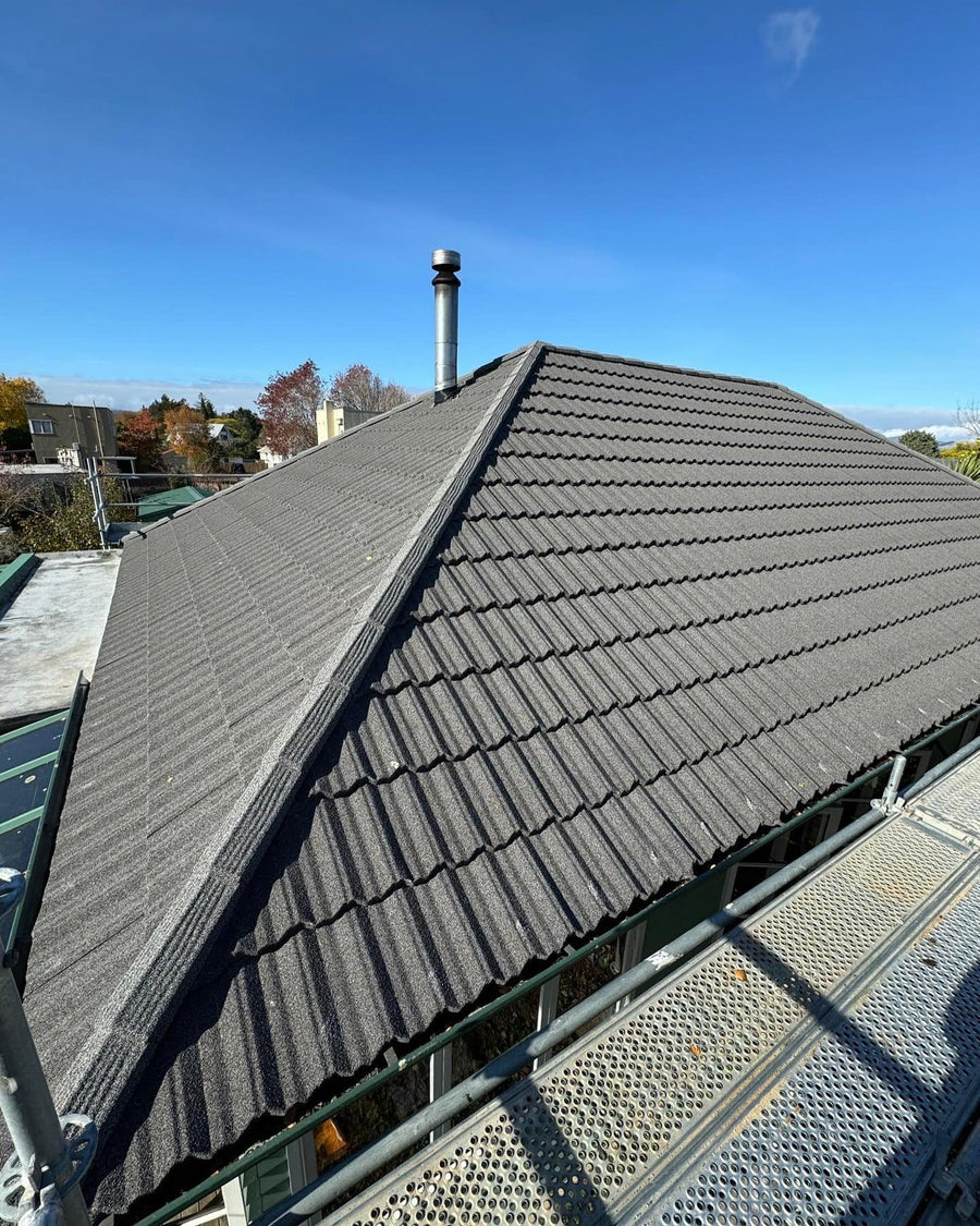 Dark metal tile roof with chimney