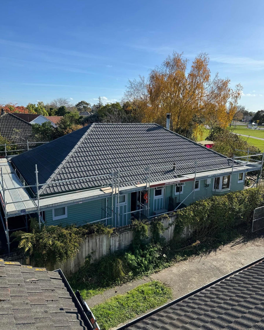 Weatherboard home re-roofed in dark grey metal tiles